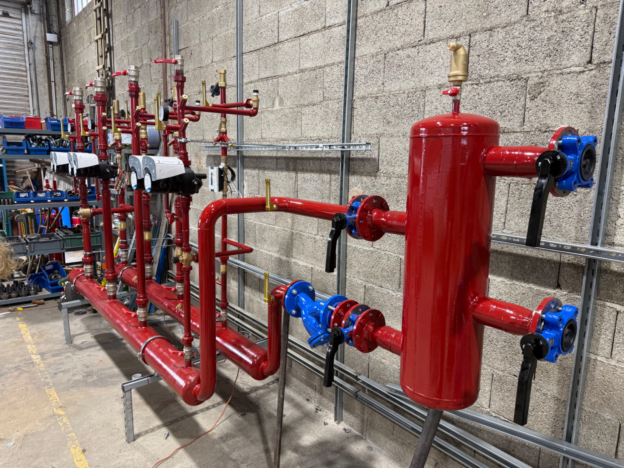 Panoplie rouge avec bouteille et organes hydrauliques dans l’atelier INNOTHERMA