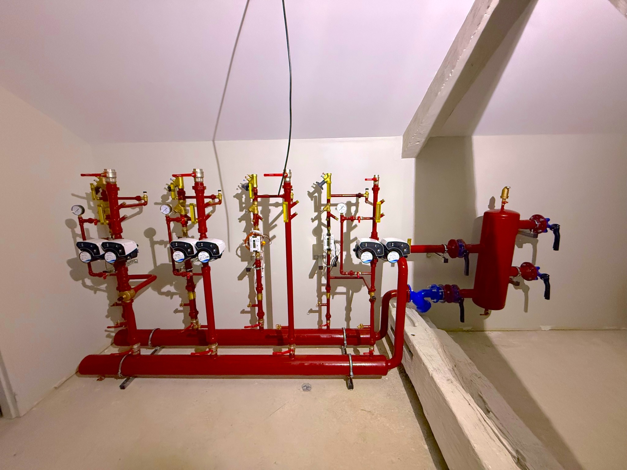 Panoplie de chauffage rouge installée dans le local technique de l’abbaye de Cluny
